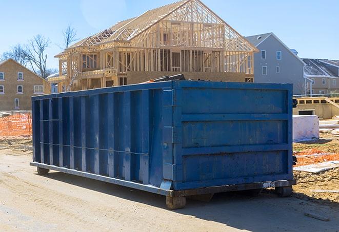 a green residential dumpster sitting outside an apartment complex